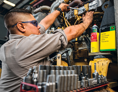 man servicing machine with Deere products